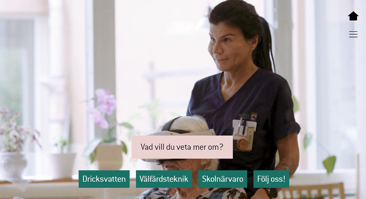 Beata Svensson, undersköterska samt en av de boende på äldreboendet som har VR-glasögon på sig. Längst ner finns fyra val som kan göras i den interaktiva berättelsen: Dricksvatten, Välfärdsteknik, Skolnärvaro samt Följ oss.